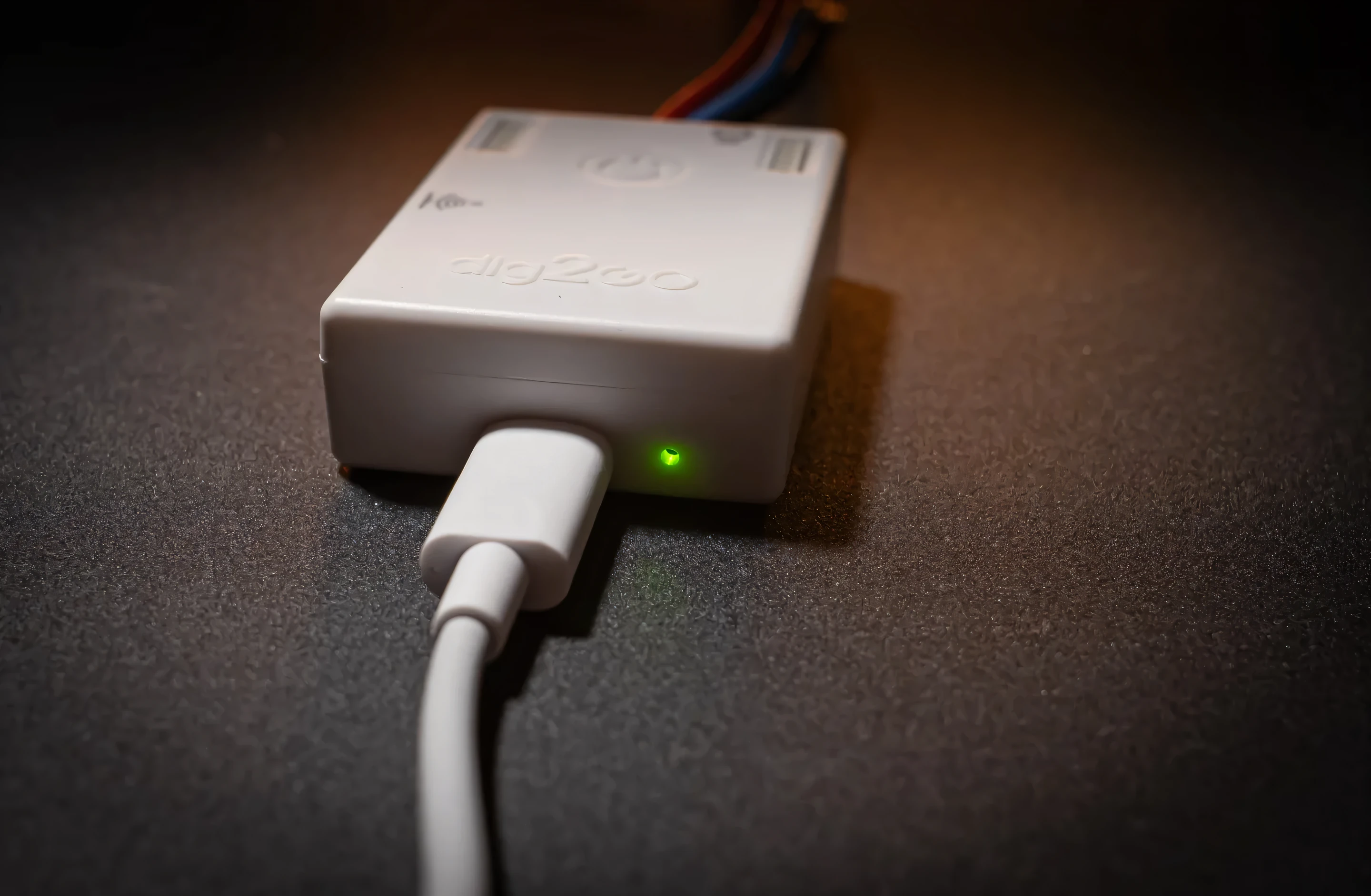 The dig2go controller running quietly with its green status light on, on a dark surface